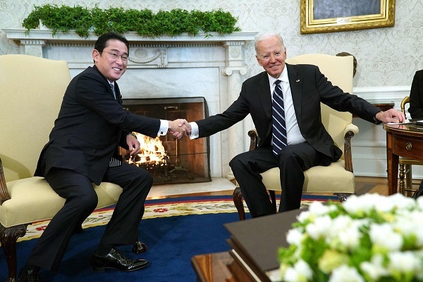 １３日、ホワイトハウスでの日米首脳会談で握手する岸田文雄首相（左）とバイデン大統領（ＡＦＰ時事）